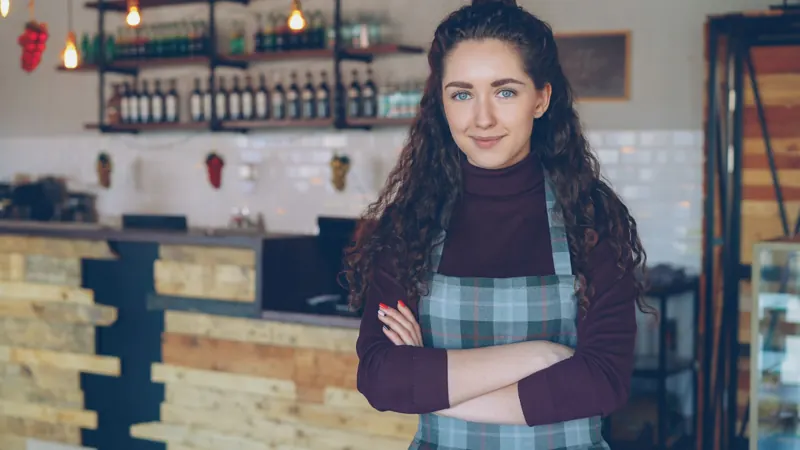 A café owner standing in her coffee shop