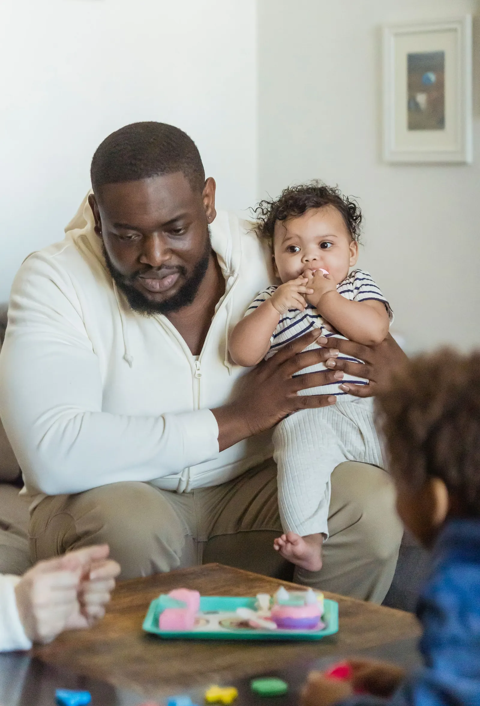 A father playing with his young children at home
